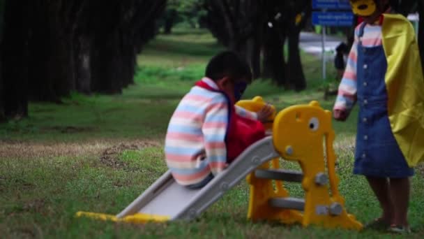 Двое Маленьких Азиатских Детей Играют Детской Площадке Костюмах Супергероев — стоковое видео