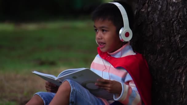 亚洲男孩坐在公园里学习 — 图库视频影像