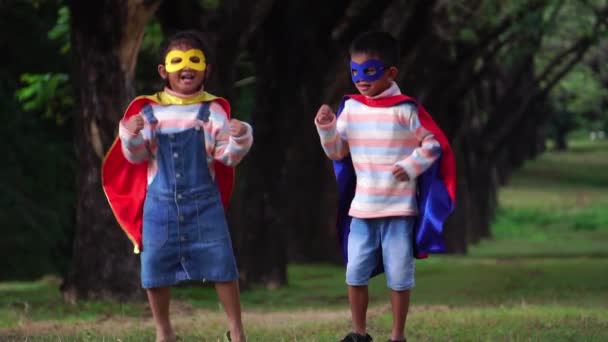 Két Kis Ázsiai Gyerek Játszik Parkban Szuperhős Jelmezben — Stock videók
