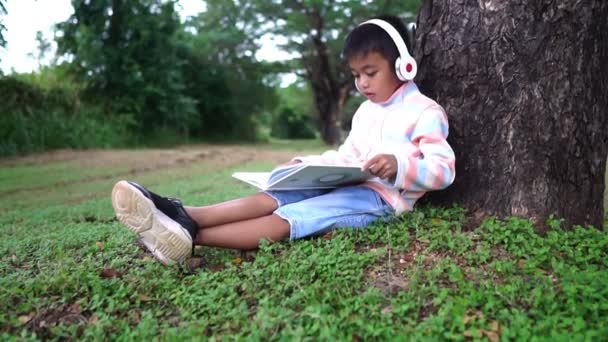 Asyalı Çocuk Parkta Oturmuş Ders Çalışıyor — Stok video