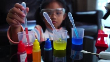 Asyalı küçük kız sıvı bilim laboratuarı deneyi yaparken eğleniyor.