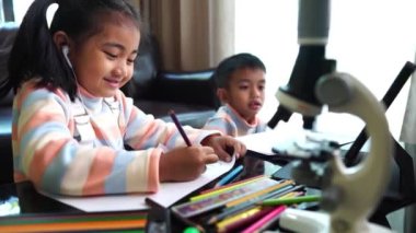 Asyalı çocuklar evden öğrenim görürken resim çiziyorlar 
