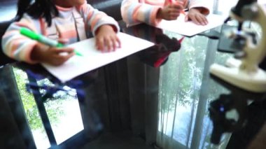 Asyalı çocuklar evden öğrenim görürken resim çiziyorlar 
