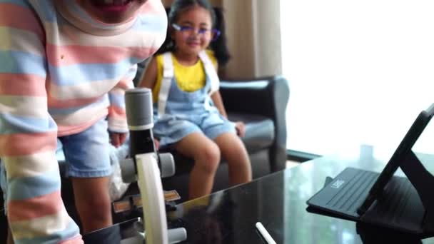 亚洲儿童在家参加网上课程并使用显微镜 — 图库视频影像