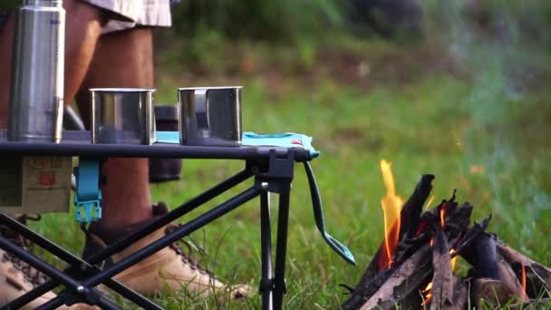 Kamp Ateşinin Yanında Elinde Iki Bardak Sıcak Içecek Olan Adam — Stok video