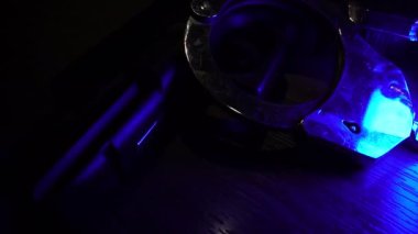 Handcuffs and gun on wooden table in flashing lights