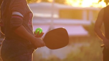 people having fun playing pickleball at sunset