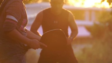 people having fun playing pickleball at sunset