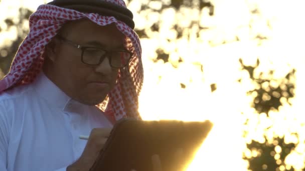 Арабский Бизнесмен Национальной Одежде Использованием Планшетных Технологий Закате — стоковое видео