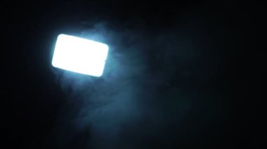 White light with blue smoke on dark background 