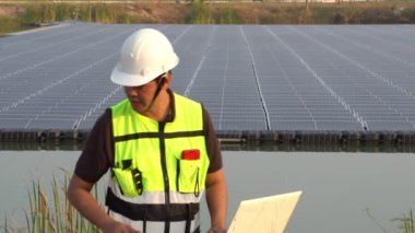 Middle Eastern engineer inspecting solar farm