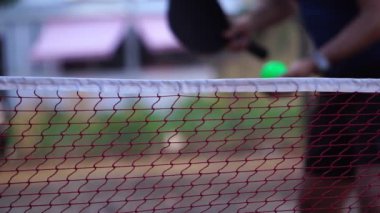 Senior man playing pickleball on an outdoor court