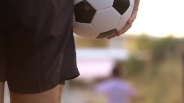 Father and son playing football outdoors