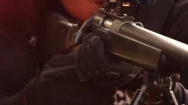 close-up footage of police sniper aiming with rifle