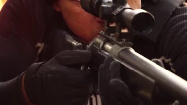 close-up footage of police sniper aiming with rifle