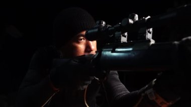 close-up footage of police sniper aiming with rifle