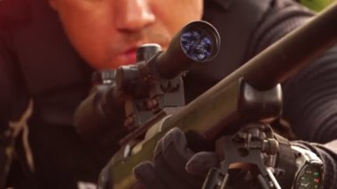 close-up footage of police sniper aiming with rifle