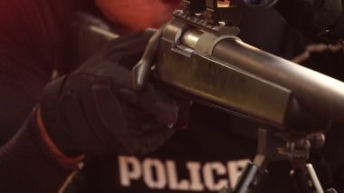 close-up footage of police sniper aiming with rifle