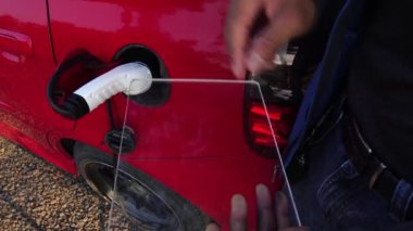 Benzin istasyonunda arabası olan birinin kırpılmış görüntüleri.