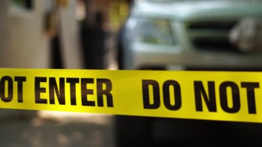 close-up footage of do not enter ribbon in front of vehicle at place of crime