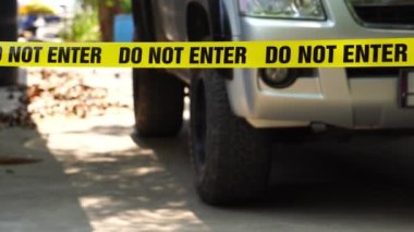 close-up footage of do not enter ribbon in front of vehicle at place of crime