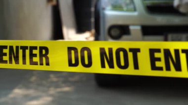 close-up footage of do not enter ribbon in front of vehicle at place of crime