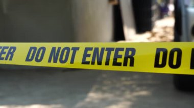 close-up footage of do not enter ribbon in front of vehicle at place of crime