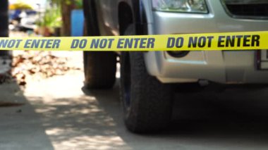 close-up footage of do not enter ribbon in front of vehicle at place of crime