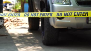 close-up footage of do not enter ribbon in front of vehicle at place of crime