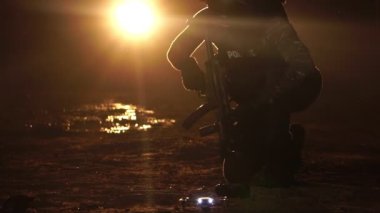 Gece caddesinde elinde silahla yürüyen bir polis memurunun görüntüsü. Anti-terörizm görev konsepti 