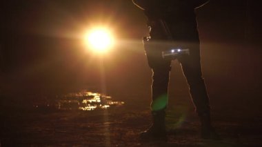 Gece caddesinde elinde silahla yürüyen bir polis memurunun görüntüsü. Anti-terörizm görev konsepti 