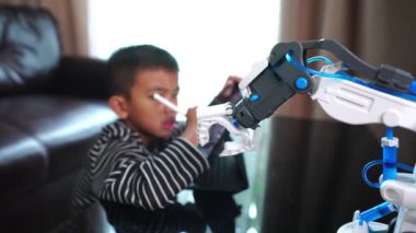 Tabletli ve kapalı mekanda robot eli olan sevimli Asyalı çocuk.