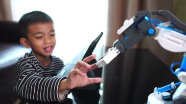 Tabletli ve kapalı mekanda robot eli olan sevimli Asyalı çocuk.