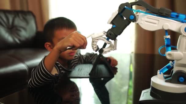 Χαριτωμένο Μικρό Ασιατικό Αγόρι Tablet Και Ρομποτικό Χέρι Εσωτερικούς Χώρους — Αρχείο Βίντεο