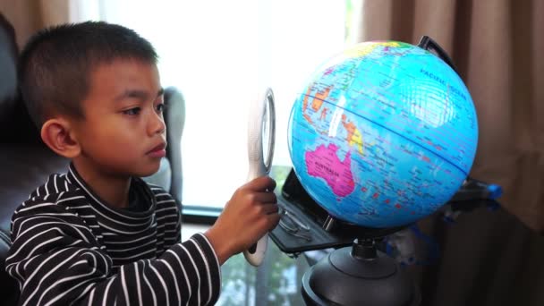 Süße Kleine Asiatische Junge Mit Globus Und Lupe — Stockvideo