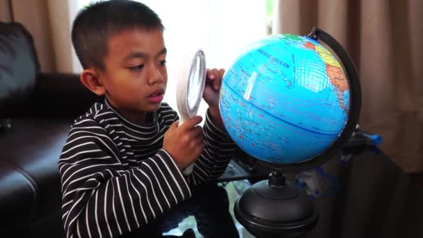 Schattig Klein Aziatisch Jongen Met Globe Vergrootglas — Stockvideo