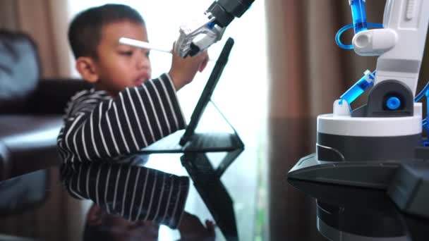 Милый Маленький Азиатский Мальчик Планшетом Роботизированной Рукой Помещении — стоковое видео