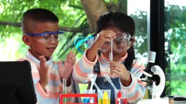 Asyalı okul çocukları okulda kimya öğreniyorlar. Yavaş çekim 