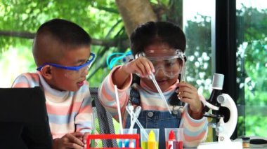 Asyalı okul çocukları okulda kimya öğreniyorlar. Yavaş çekim 