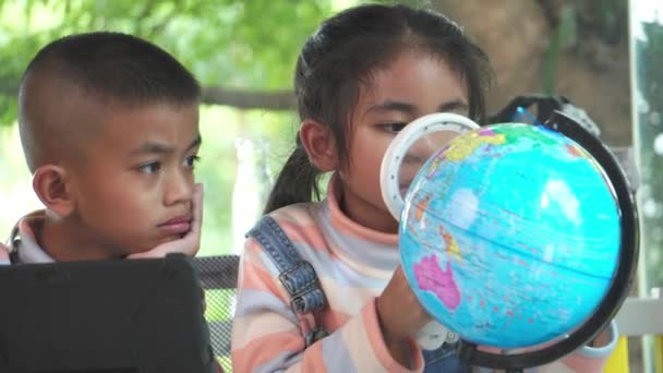 Asian Children Inspecting Model Earth Magnifying Glass — Stock Video