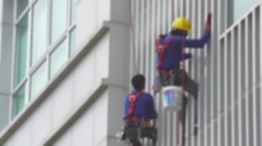 Bir iş gökdeleninin dış camlarını temizleyen işçiler.