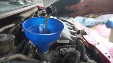 Araba tamircisi arabaya yağ döker.