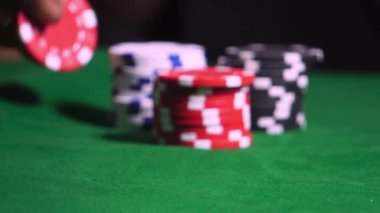 Kumarhanedeki yeşil poker masasında çiplerle bahis oynayan bir erkek. Yakın plan.. 