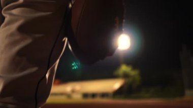 Gece stadyumda futbol topuyla Amerikan Futbolcusu 