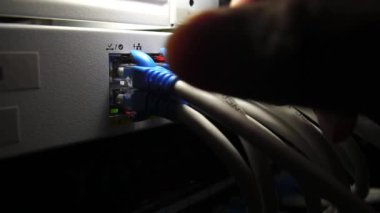 Veri sunucusundaki kabloları kapat ve işçi eli bir kabloyu çıkar 