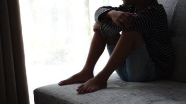 Mutsuz çocuk kanepede tek başına oturuyor ve sorunu düşünüyor.