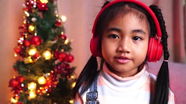 クリスマスに喜んで笑顔のカメラを見ているアジアの女の子 — ストック動画