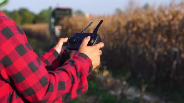 概念智能农场 控制和检查自动化机械操作的女农民在农场收获庄稼 — 图库视频影像
