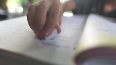 Okullu çocuğun eli silgiyle yanlış cevabı siliyor.