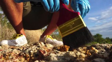 Kamera 4K: Erkek arkeolog fosil çıkarıyor.